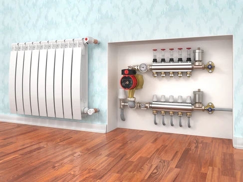 Intérieur résidentiel avec radiateur à ailettes blanches fixé au mur et système de chauffage centralisé visible dans niche murale