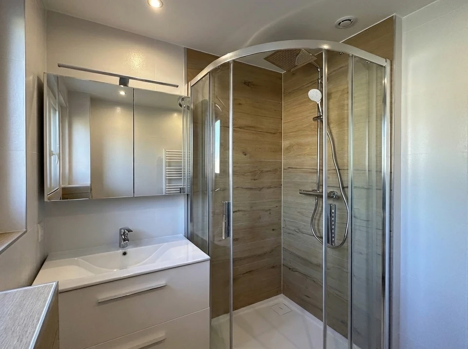 Salle de bain moderne avec meuble vasque en bois foncé, plan de travail blanc, robinetterie chrome trois trous